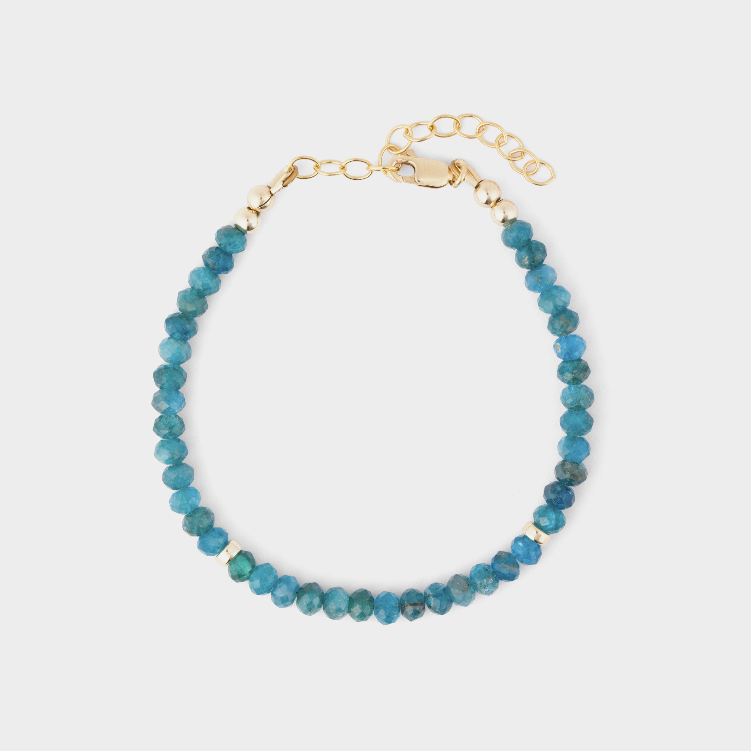 Delicate blue apatite bracelet featuring gold-filled clasps, laid flat against a clean white backdrop.