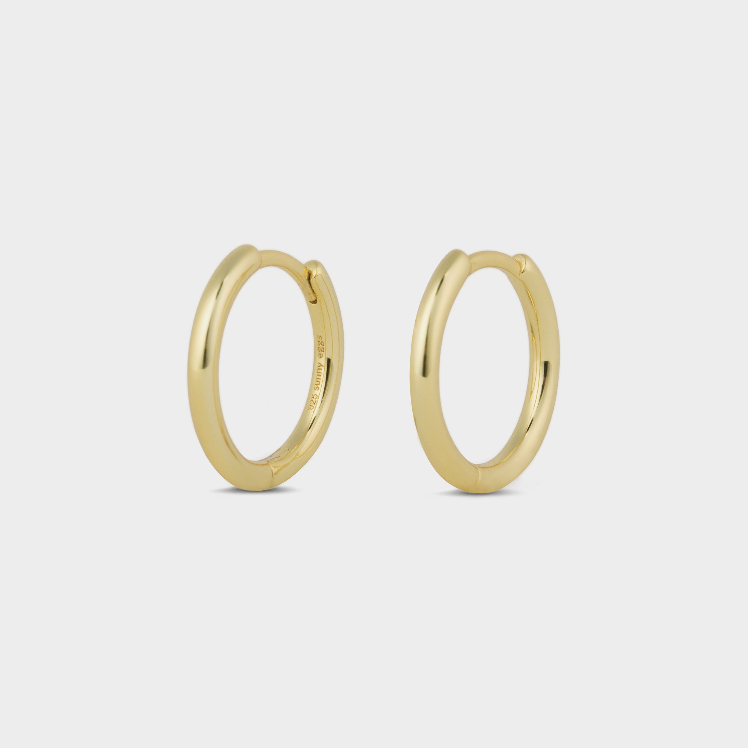 A pair of classic gold hoop earrings displayed on a white background.