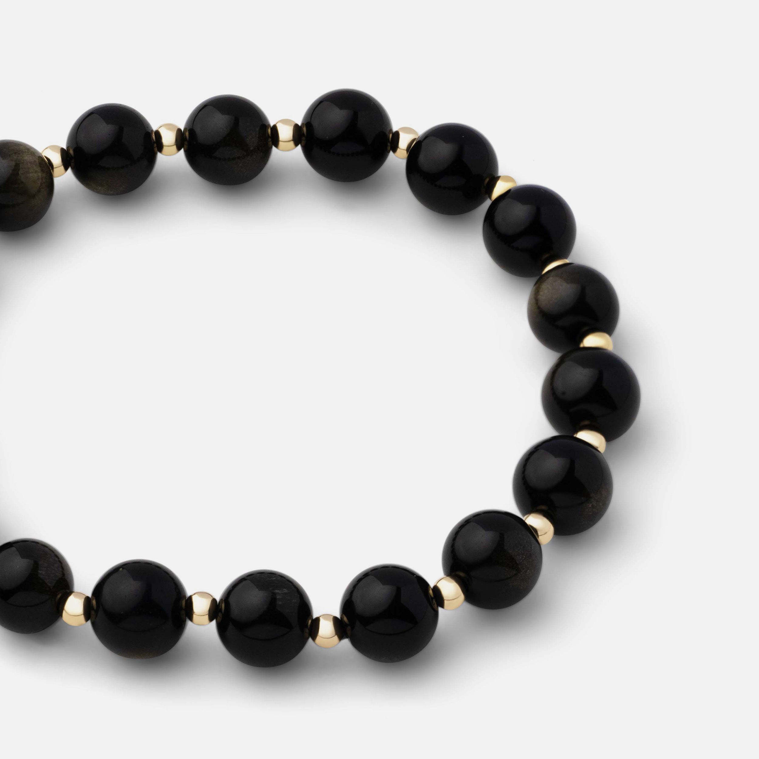 Close-up of a bold and classic bracelet featuring natural black obsidian gemstone beads, demonstrating its powerful and resilient qualities, ideal for solo wear or stacking with other bracelets.