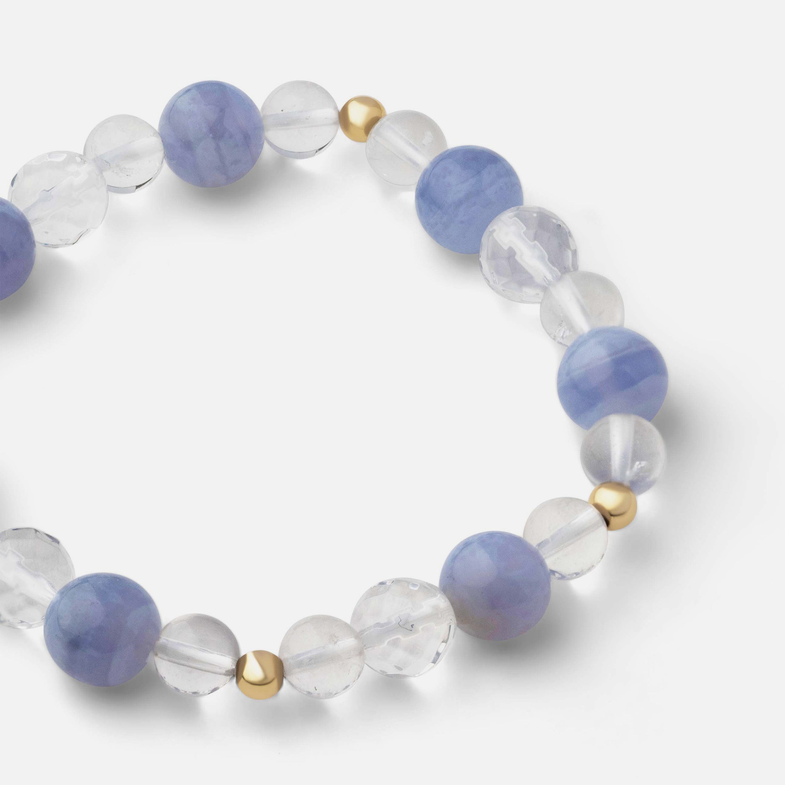 Close-up of an exquisite blue lace agate bracelet showing layered bands from light to sapphire blue, paired with clear quartz for added flair, ideal for solo wear or stacking with other bracelets.