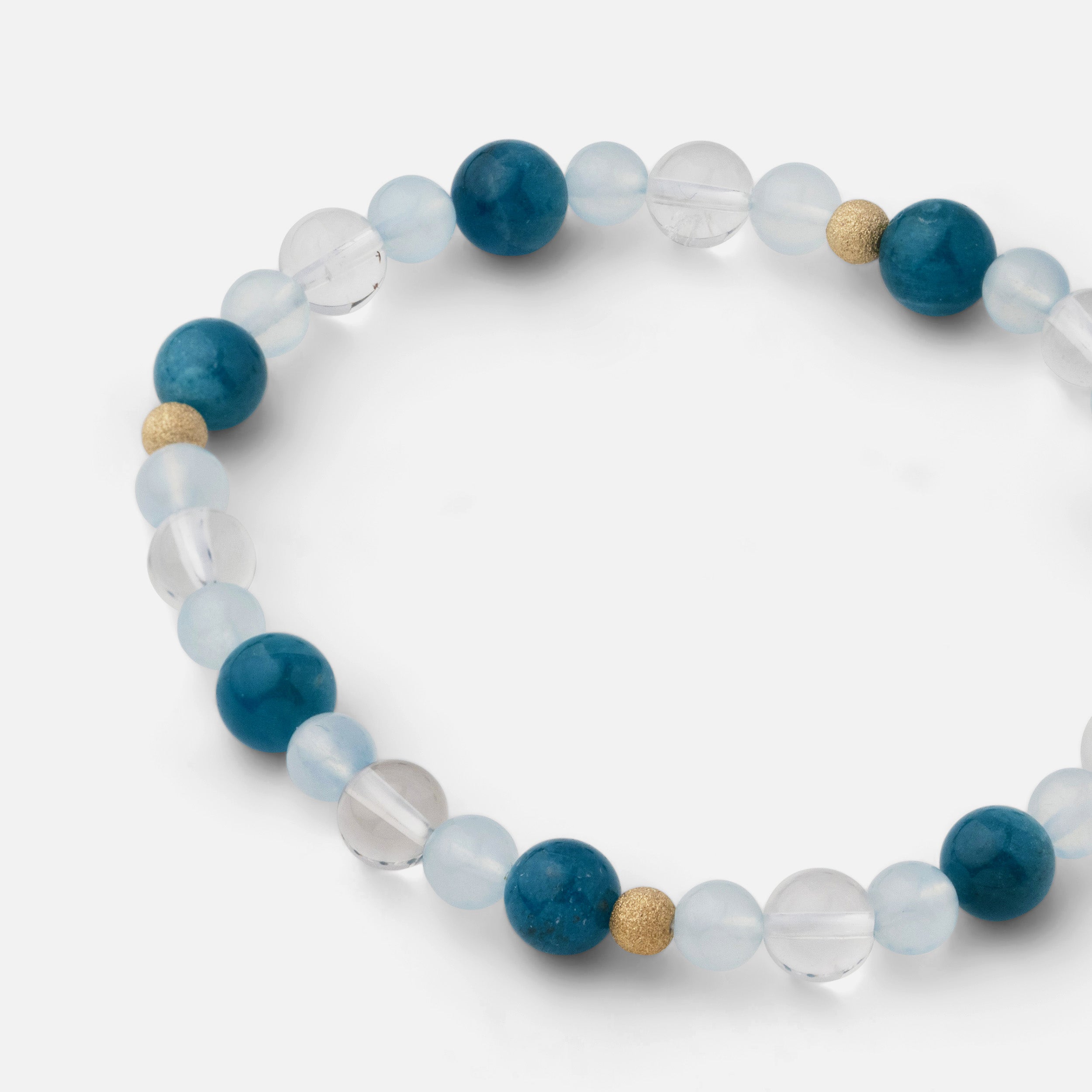 Close-up of a bracelet with small beads (4-8mm) of electric blue apatite, clear blue aquamarine, and clear quartz, reminiscent of refreshing beach waves and the beautiful ocean, ideal for wearing alone or stacked with other jewelry