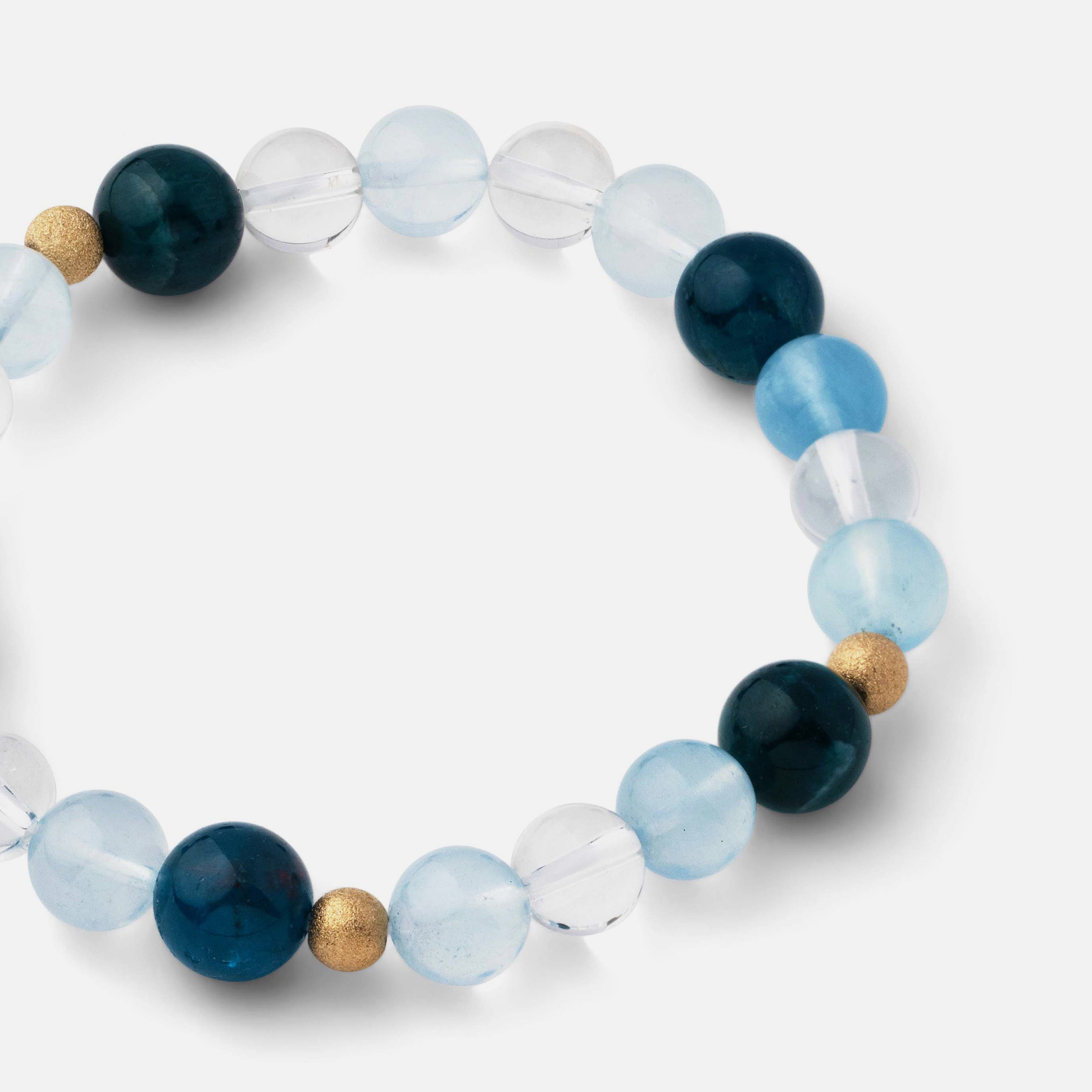 Close-up of a bracelet featuring medium-sized beads (5-9mm) of electric blue apatite, clear blue aquamarine, and clear quartz, capturing the essence of refreshing beach waves and the ocean's beauty, ideal for wearing alone or stacked with other jewelry.