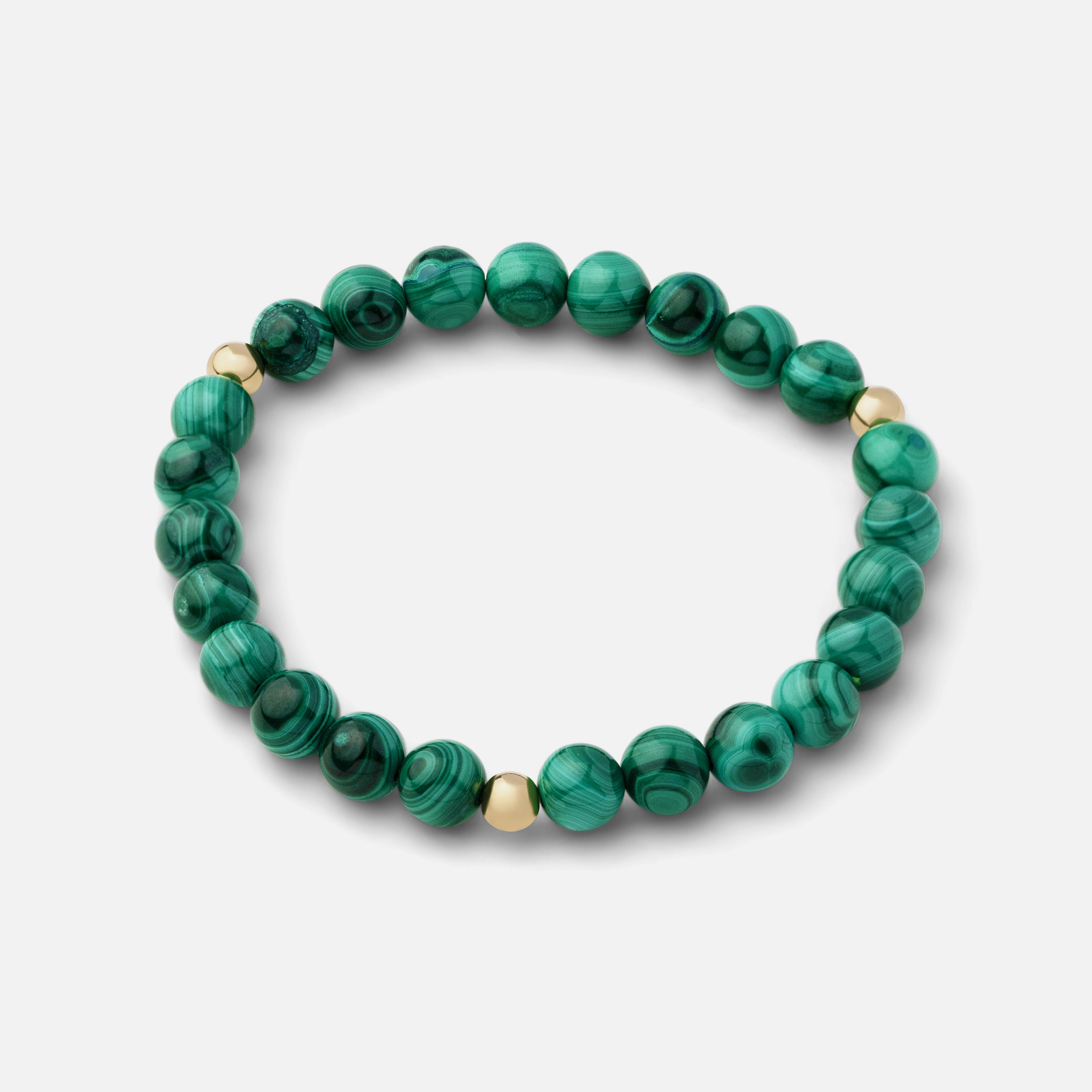 Rich green malachite bracelet with beautiful banding and plume-like patterns, versatile for wearing solo or paired with other gold jewelry pieces.