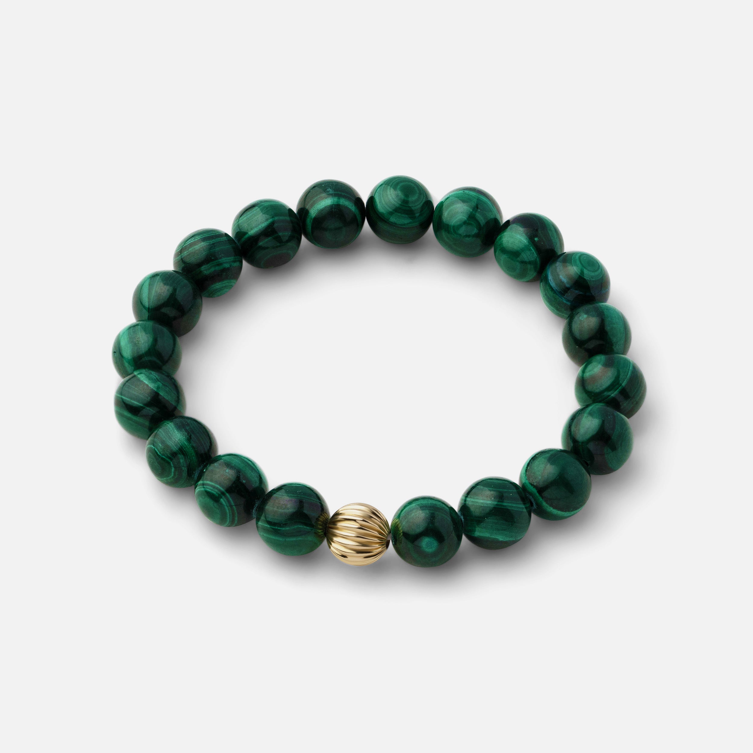 Rich green malachite bracelet with beautiful banding and plume-like patterns, making it a versatile piece that can be worn solo or paired with other gold jewelry.