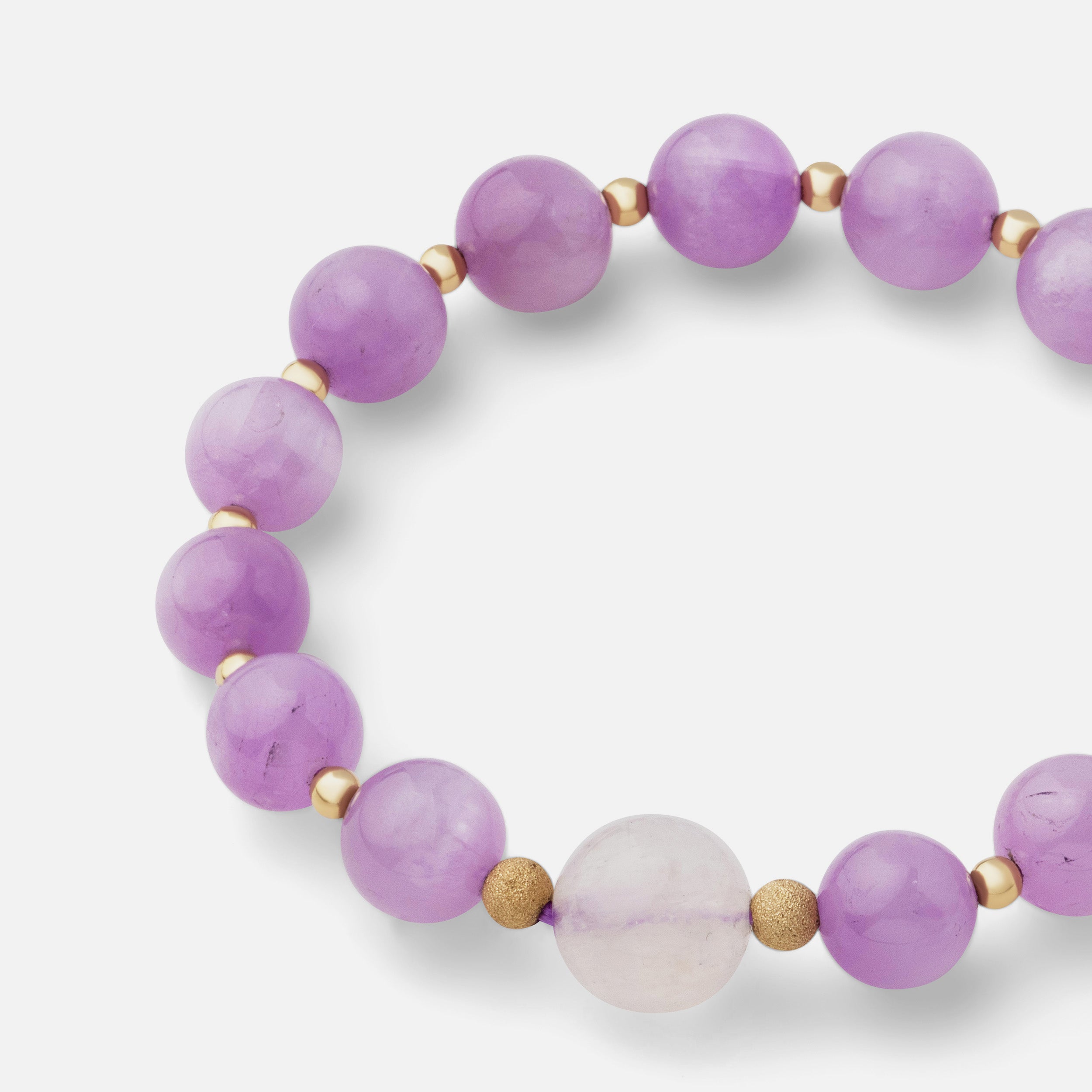 Close-up of a bracelet with beautiful pale pink and lavender kunzite and flashy moonstone, showcasing a timeless and elegant style, perfect for layering with gold pieces or wearing solo.