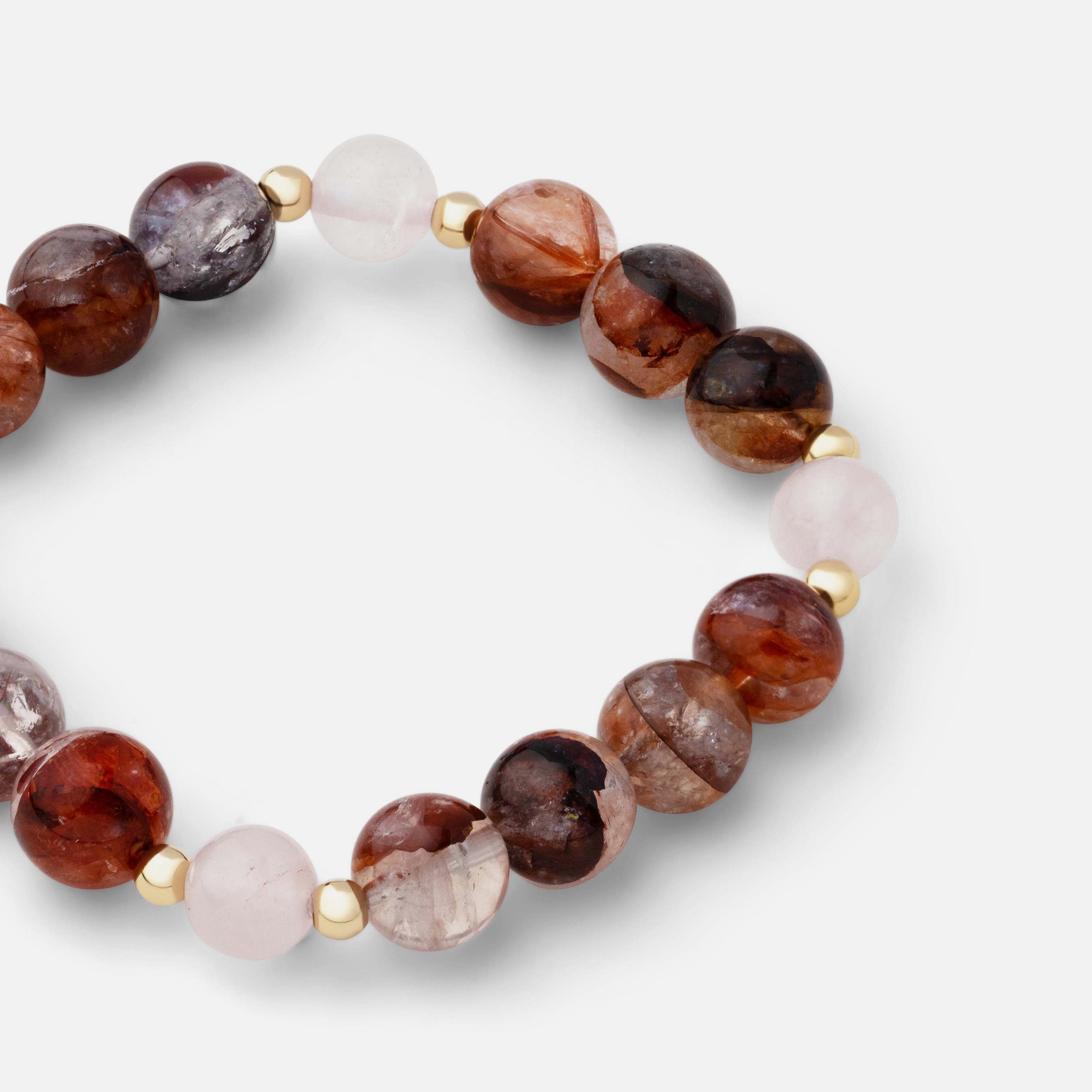 Close-up of a bracelet featuring stunning red, orange, and pink natural inclusions of fire quartz combined with translucent pale pink rose quartz, perfect for dazzling on special occasions.