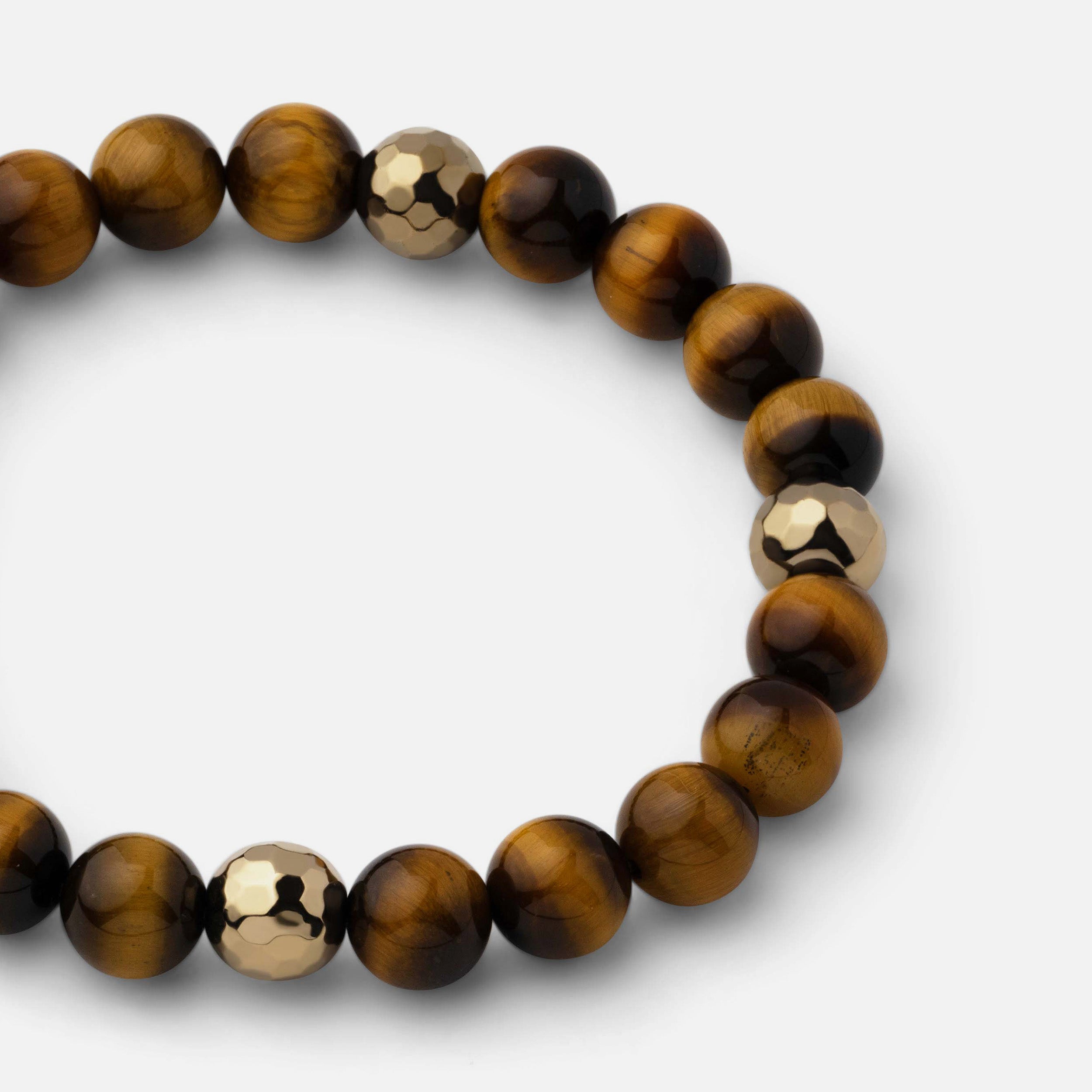 Close-up of a bracelet showcasing the silky luster of reddish-brown tiger eye, paired with natural black obsidian beads and metallic pyrite, creating a powerful and resilient look.