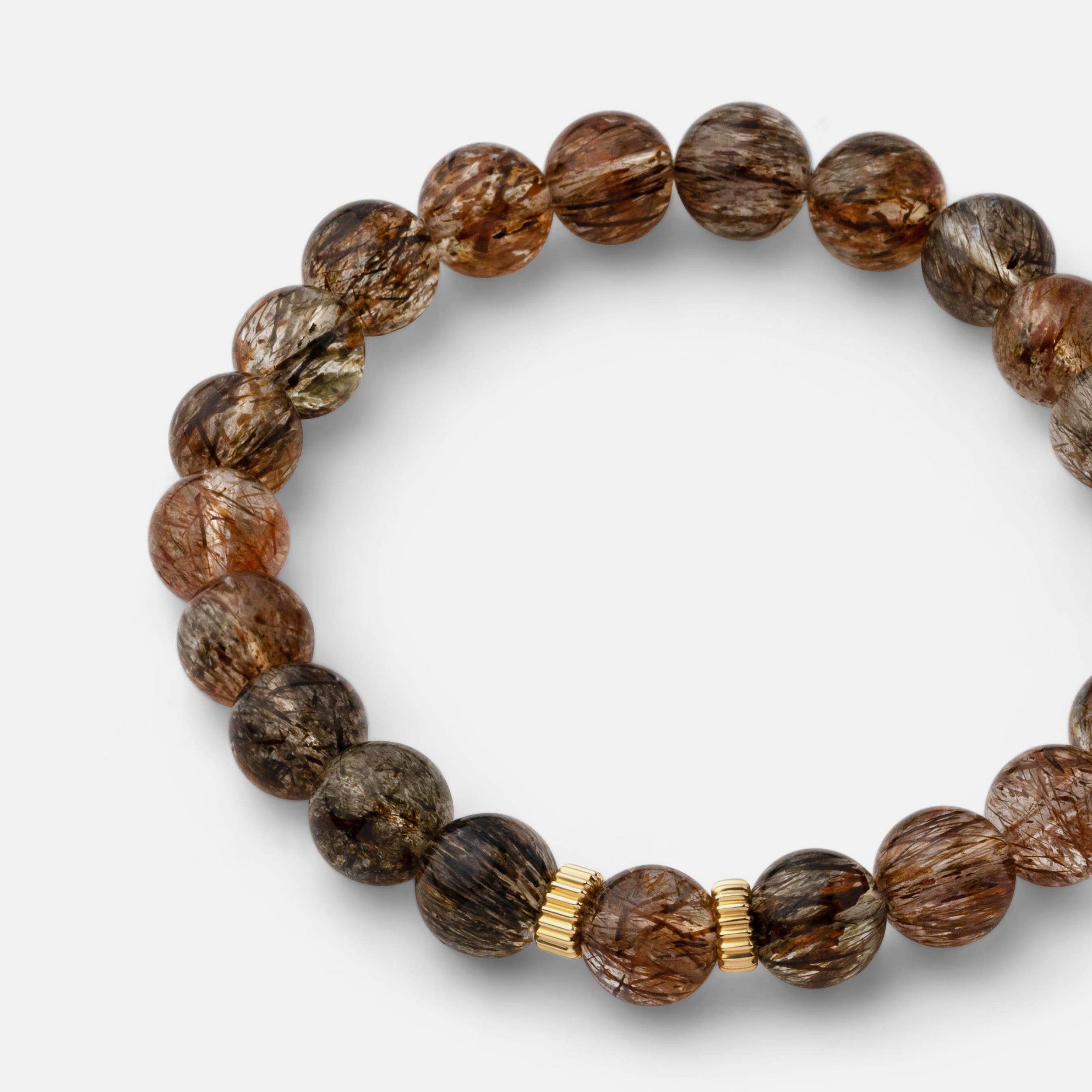 Close-up of a bracelet showcasing quartz with intricate patterns of tiny black copper-colored rutile needles, creating a classic and elegant style, ideal for solo wear or layering with gold jewelry.