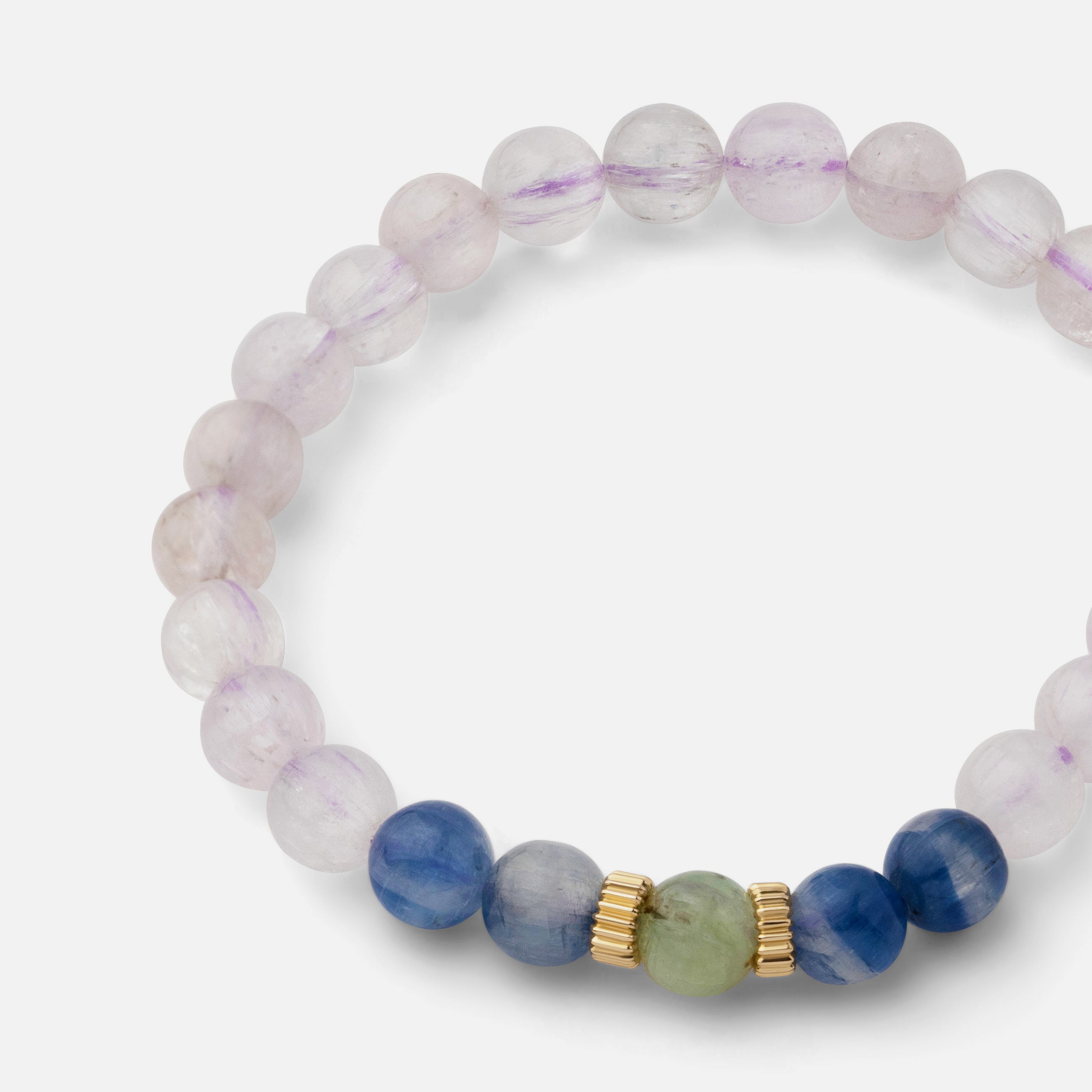 Close-up of a bracelet showcasing rare cat eye kunzite gemstones with natural exterior lines, complemented by blue and green kyanite, creating a lustrous and elegant look for special occasions.