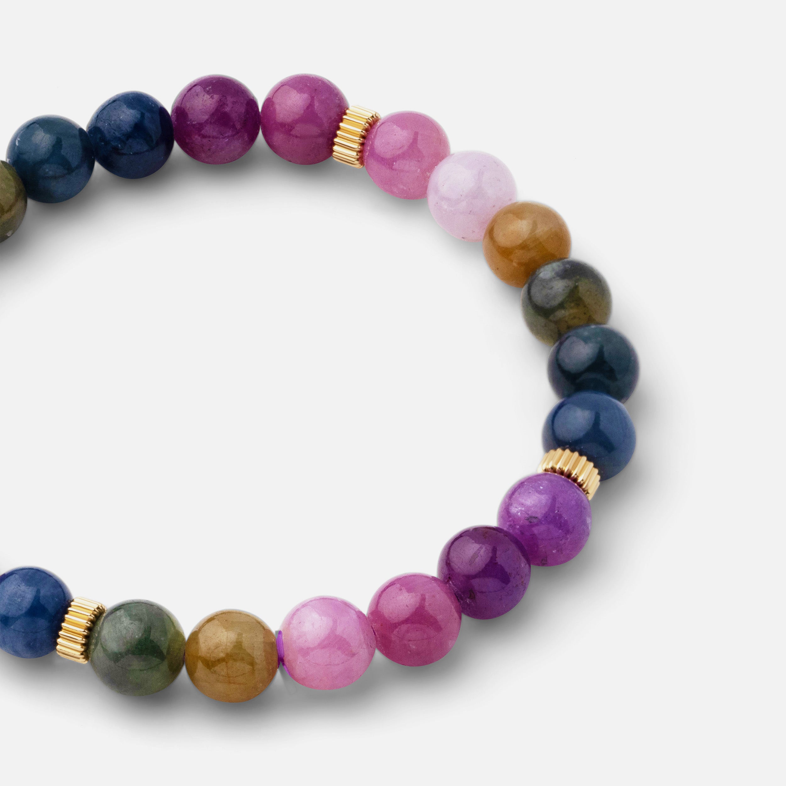 Close-up of a bracelet featuring colorful shades of tourmaline beads ranging from pink to green, adding a fun touch to any look. Perfect for wearing solo or stacked with other bracelets.