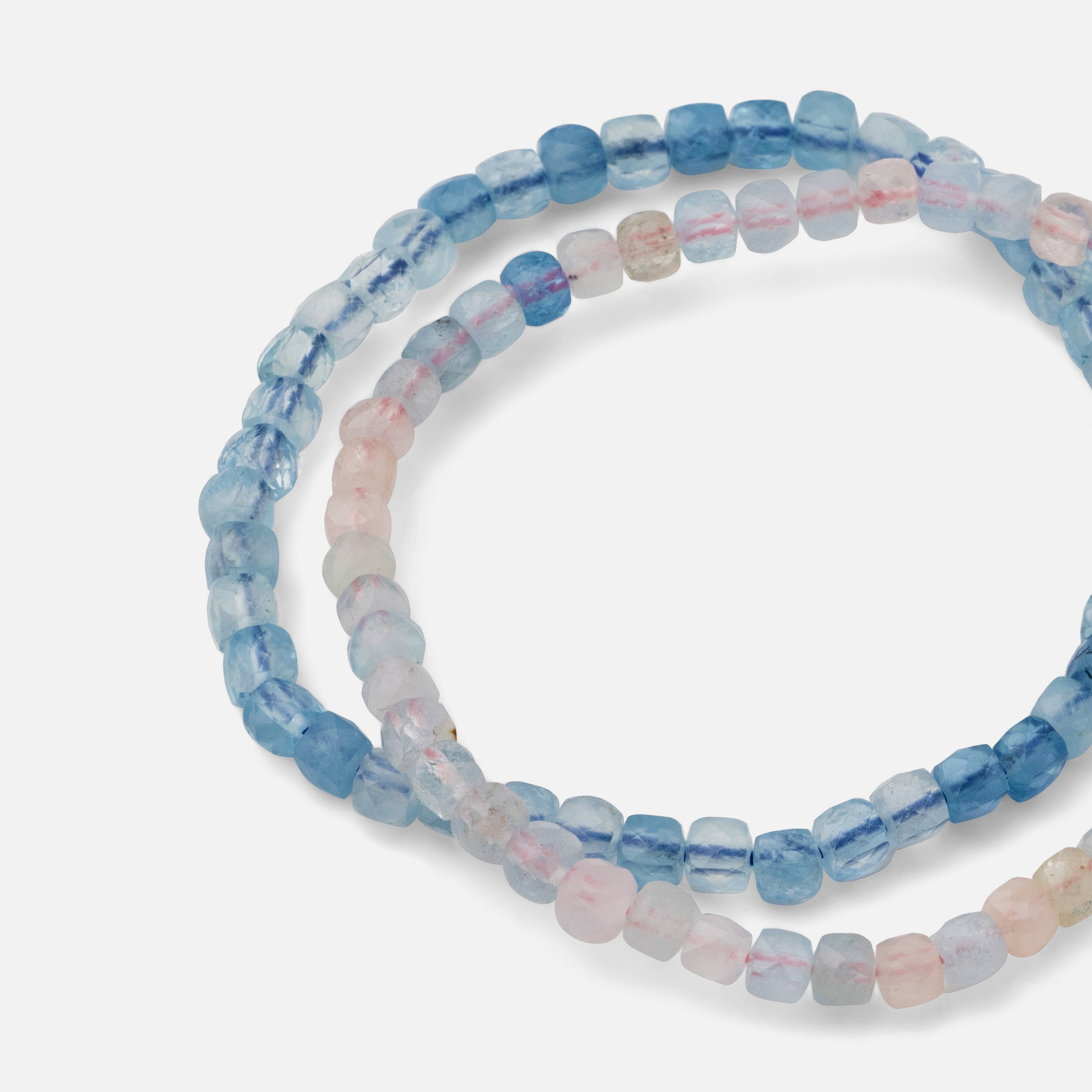 Close-up of a bracelet featuring clear blue aquamarine and vibrant, translucent morganite gemstones, showcasing a fresh and versatile look perfect for any season.