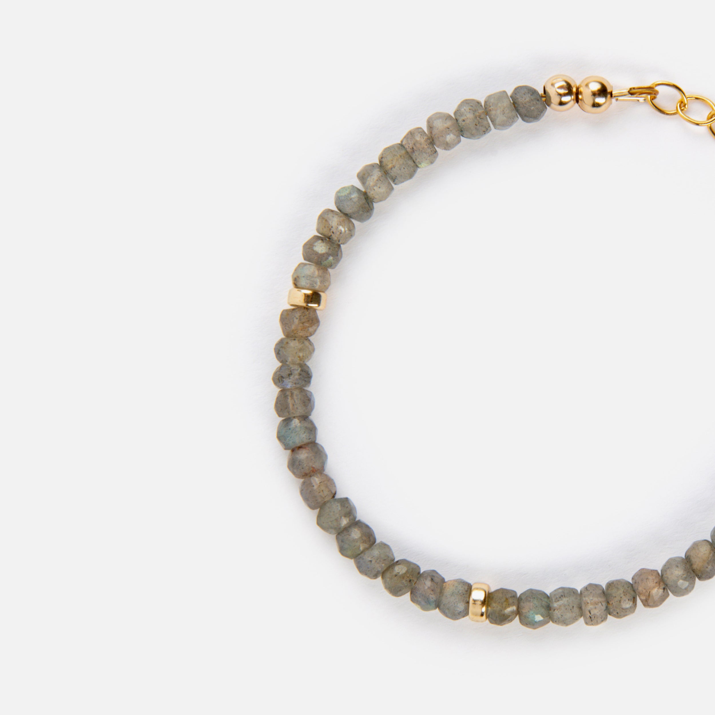 A close-up view of a flashy faceted rondelle labradorite bracelet, showcasing its iridescent surface that reflects a blue shimmer. The labradorite gemstones are paired with tarnish-resistant 14K gold-filled components, making it easy to wear every day while emphasizing the gem's natural beauty and shine.