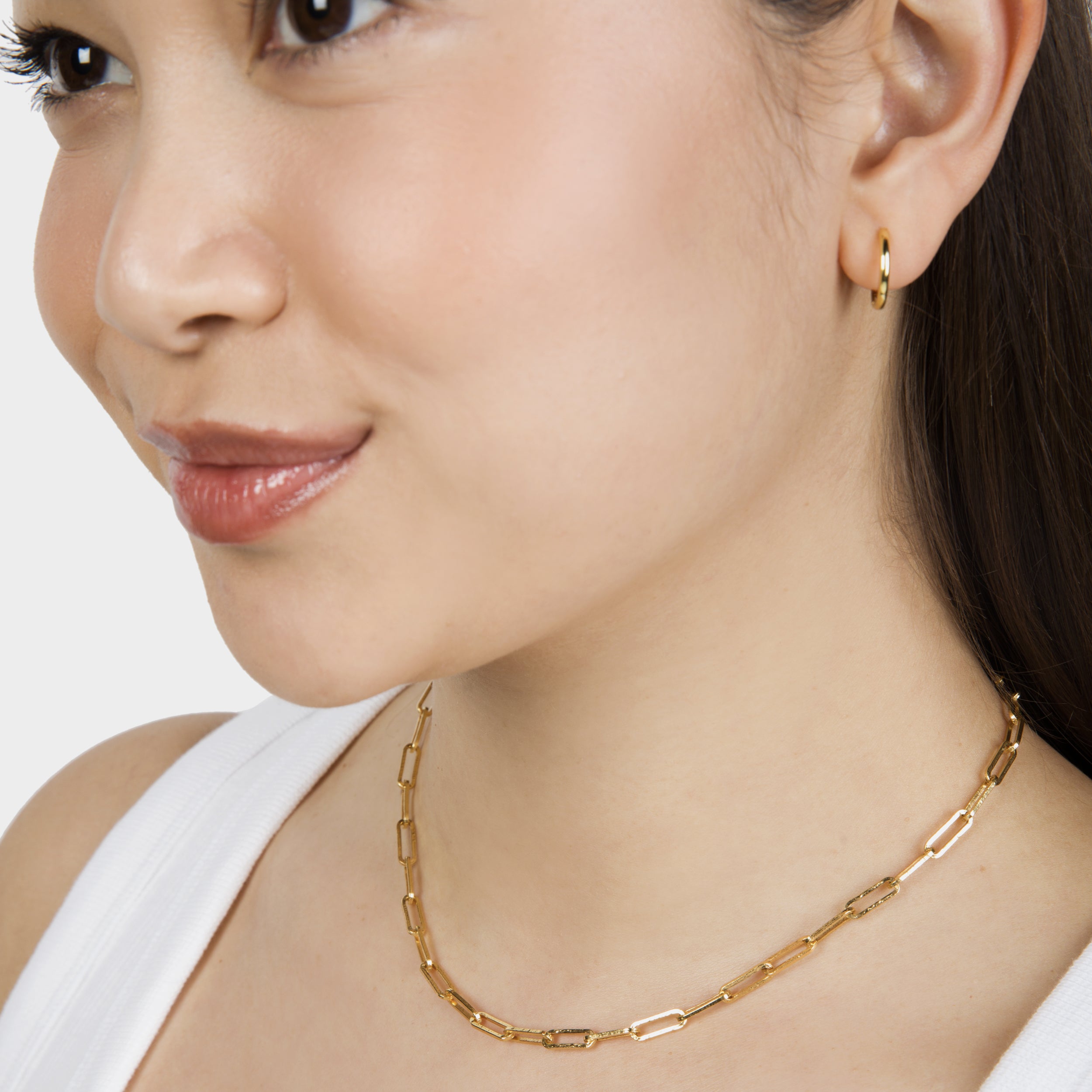 Close-up of a model wearing a chunky paperclip necklace with interlocking links.