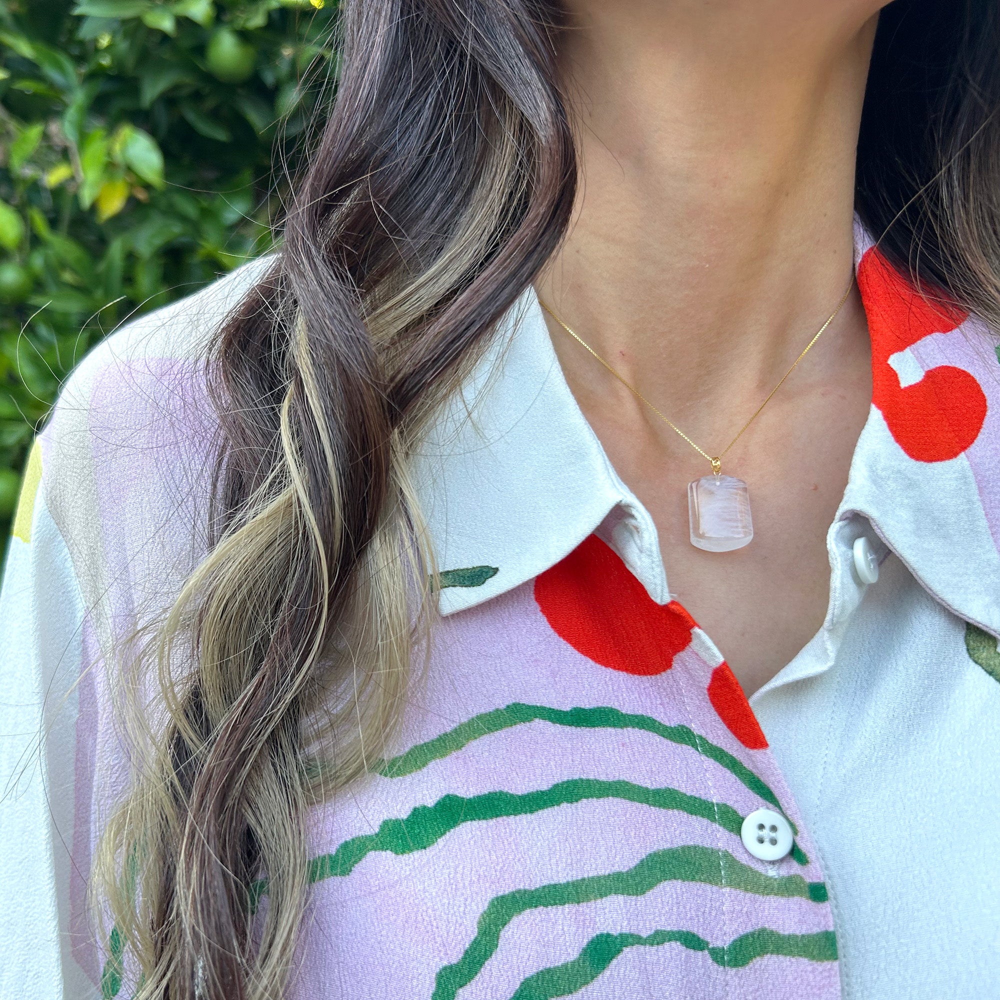 Close-up of a model wearing a stunning blue needle quartz pendant with an 18K solid gold clasp, showcasing its classic design, perfect for any occasion.